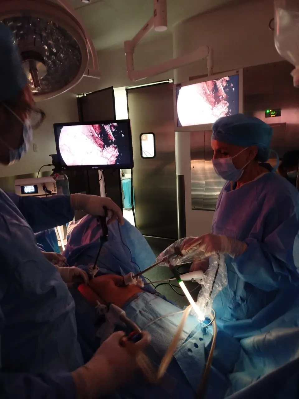La Dra. Birlain operando con instrumentos de laparoscopía frente a los monitores del quirófano, Star Médica Querétaro